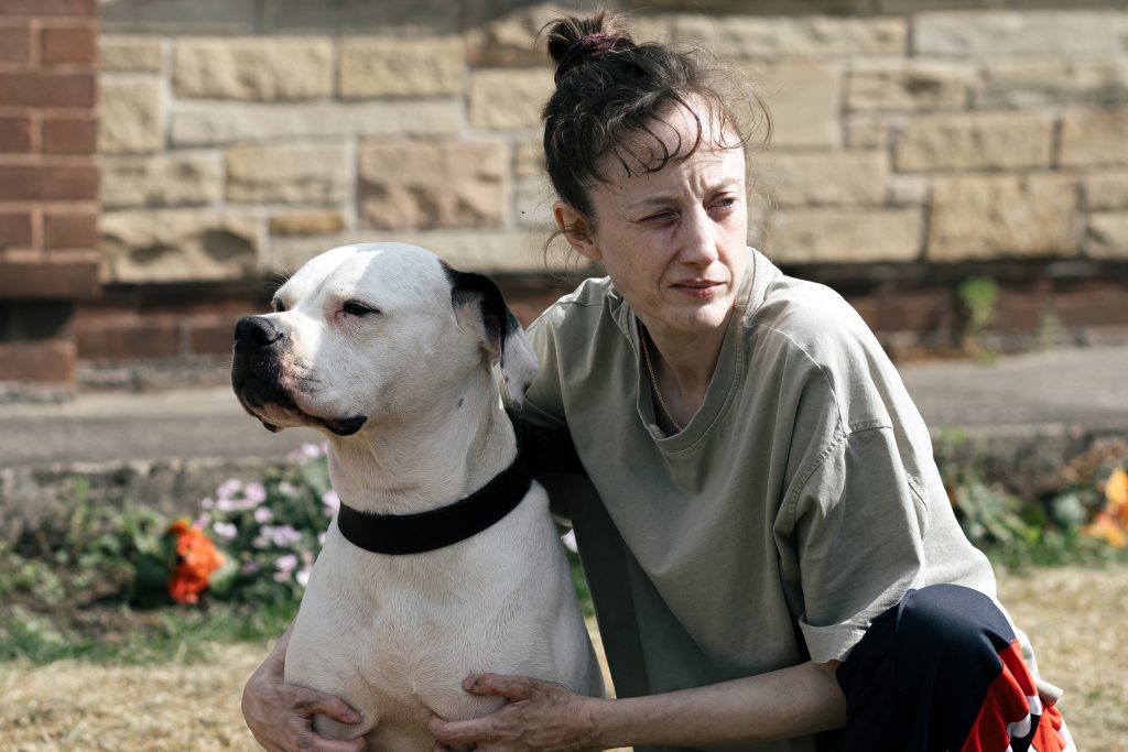 Dragonfly - Colleen crouching beside her dog Sabre